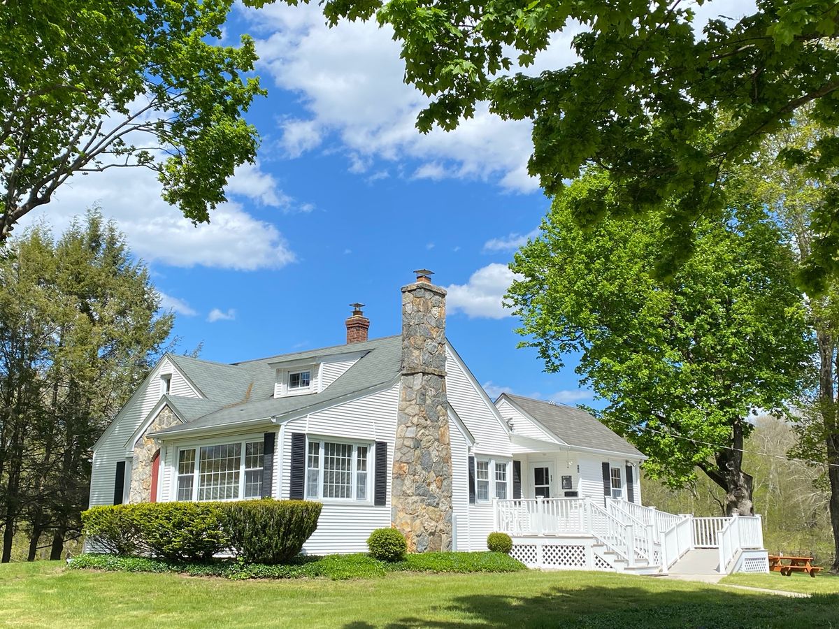 The white farmhouse with its stone chimney