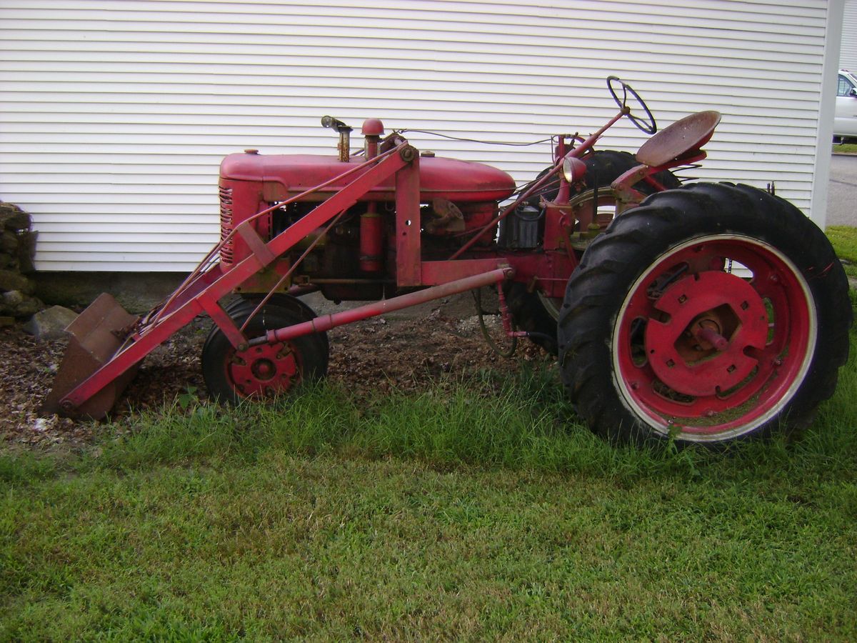 The old red tractor beside the barn